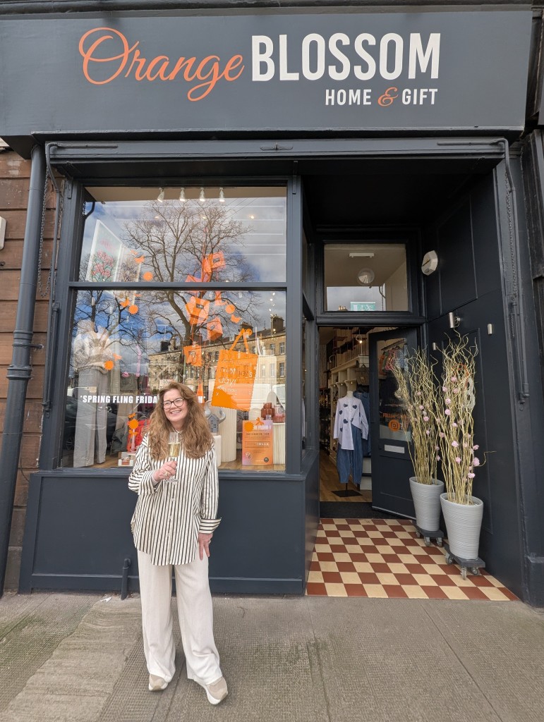 Above: Orange Blossom Home & Gifts’ owner Shirley McIver celebrating with a glass of fizz.